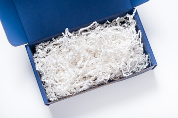 Blue carton cardboard box with paper filler, top view, isolated