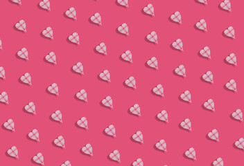 Creative pattern made of crochet heart shape on pastel pinky background.  