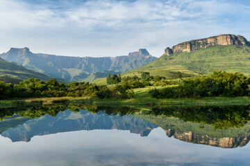 Mirror like reflection in water of the Amphitheater Drakenberg Mountains in the Royal Natal Nature...