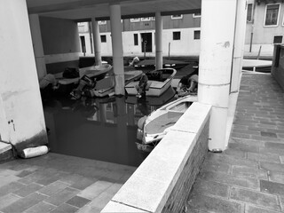 Venice, Italy, January 27, 2020 evocative black and white image of boats moored under a modern house
