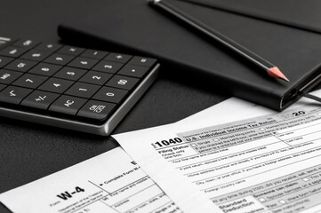 Tax forms with calculator and notepad on the office workplace.