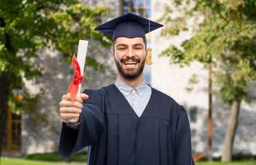 education, graduation and people concept - happy smiling male graduate student in mortar board and...