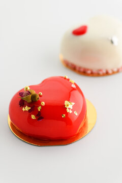 A cake in heart shape. Cupcakes in the shape of a heart on a white background. Valentine's Day. Vertical photo