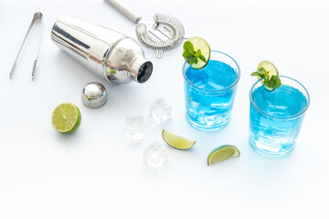 Blue cocktail drinks with bar tools and ice, close up