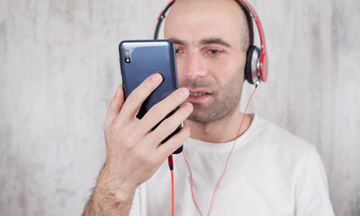 Caucasian man in headphones using smartphone. Listening music
