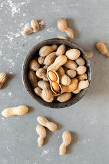 Roasted peanuts, cracked. On a grey background