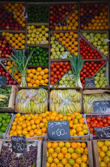 Market vendor with fruits and vegetables in boxes in small grocery shop along the street. Mar del Plata, Argentina