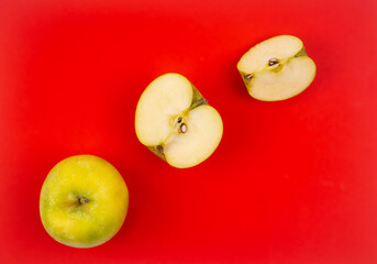 Fresh red apple on red background.