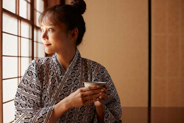 旅館でリラックスする浴衣姿の若い女性