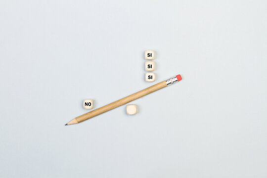 Cubos de madera escrito con Si o No colocados en forma de balanza sobre un fondo gris aislado. Vista superior. Copy space. Concepto: Equilibrio 