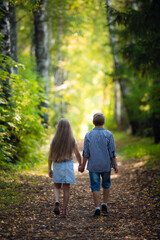 Fototapeta premium Beautiful boy and girl walking in the beautiful summer forest