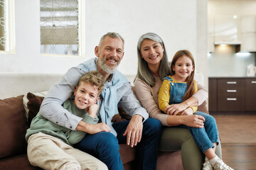 Portrait of happy family spending time at home, grandparents and grandchildren relaxing on sofa in...