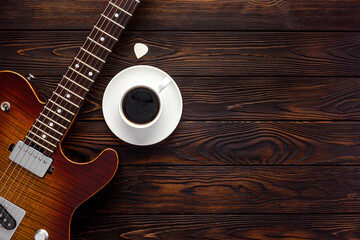 Fototapeta premium Beautiful electric guitar on with headphones and coffee desktop