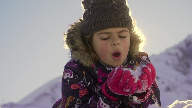 girl playing with snow in the mountains fim in slow motion