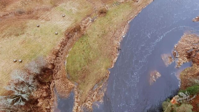 Red sandstone cliffs in the banks of river Salaca during late autumn time, Latvia. Real time drone footage