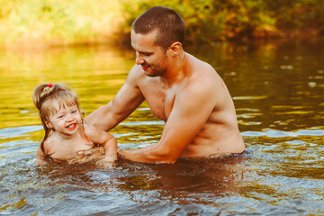 the father with the child in the water