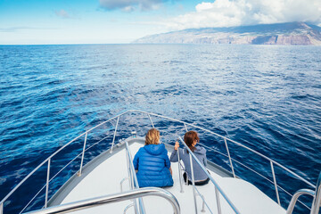 Obraz premium Couple enjoys the view of the coast of Tijarafe on the island of La Palma from the bow of a recreational boat, La Palma, Santa Cruz de Tenerife, Canary Islands, Spain, Europe.