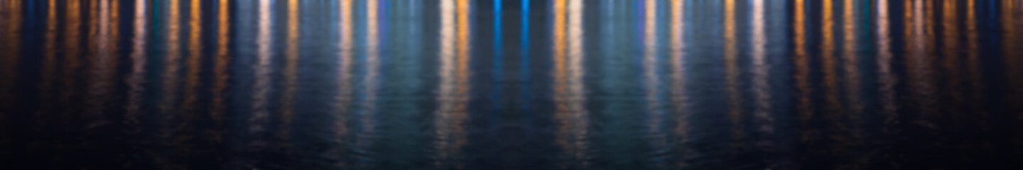 Water texture with colored lights reflected in it at night
