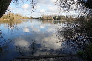 Sky reflection in waters of the lake in Milton Country Park, Cambridge, UK