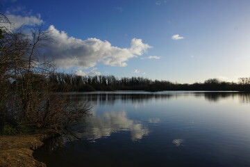 Sky reflection in waters of the lake in Milton Country Park, Cambridge, UK