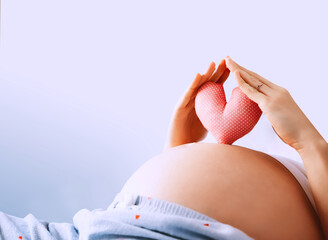 Pregnant woman holds symbol in heart shape. Loving mother waiting of baby. Concept of maternity,...