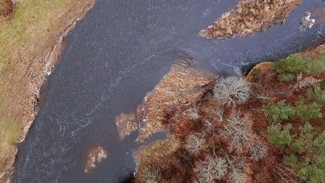 Red sandstone cliffs in the banks of river Salaca during late autumn time, Latvia. Real time drone footage