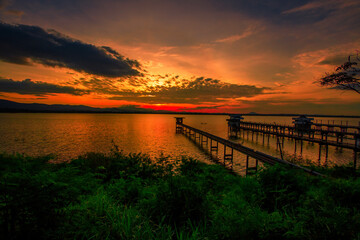 Fototapeta premium The background of the bridge stretches into the sea, with twilight light in the morning, beautiful colors, sky wallpaper and refreshing surroundings.