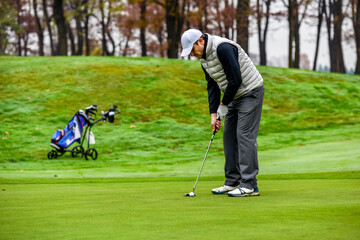 Plakat Close-up of a golf player on course aiming for put shot during a tournament