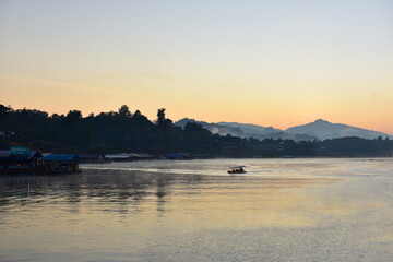 An early morning view with beautiful colorful lights Before sunrise At the Fisherman Village near Mon Market at Mon Bridge, Sangkhlaburi District, Kanchanaburi Province, Thailand