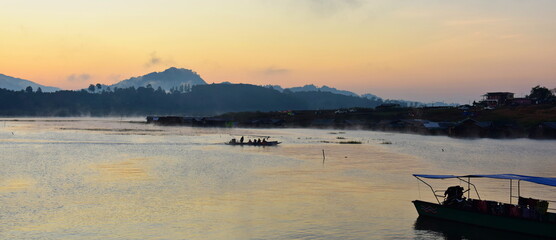 An early morning view with beautiful colorful lights Before sunrise At the Fisherman Village near Mon Market at Mon Bridge, Sangkhlaburi District, Kanchanaburi Province, Thailand