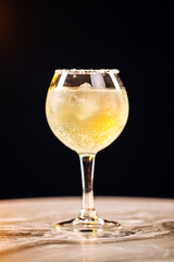 Vertical closeup on glass of margarita cocktail with salt