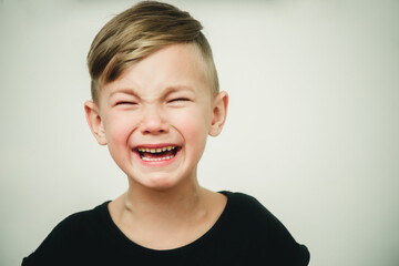 close-up portrait of a crying boy on a white background