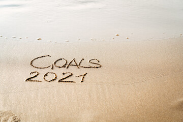 foamy sea water and Inscription Goals 2021 on the sandy beach