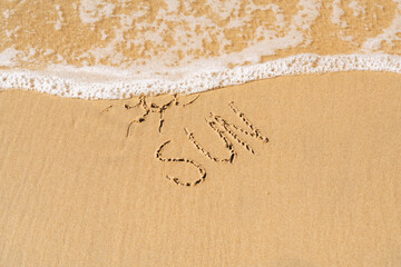 sun drawn on the sea sand. vacation concept