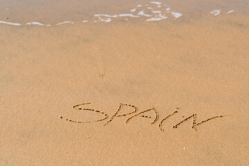 Spain inscription on the sea sand