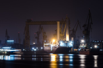 SHIPYARD - Ships, Cranes, wharves and industrial infrastructure in night illumination - obrazy, fototapety, plakaty