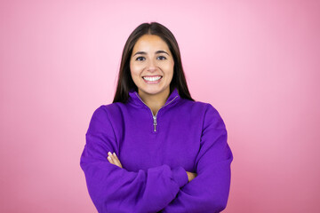 Young beautiful woman wearing sweatshirt over isolated pink background with a happy face standing and smiling with a confident smile showing teeth with arms crossed