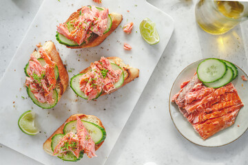 Toasts with fresh cucumber and smoked salmon served with lime shavings
