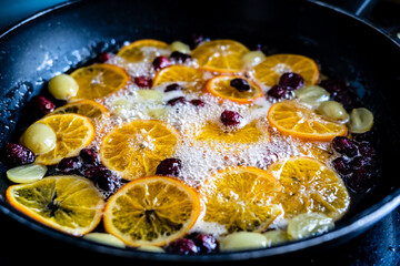 candied fruit in a pan to make a dessert mandarin orange grape and cranberry cherry