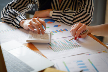 Close up of businesswoman working on calculator to calculate business data the financial report in meeting room. Business financial analysis and strategy concept.