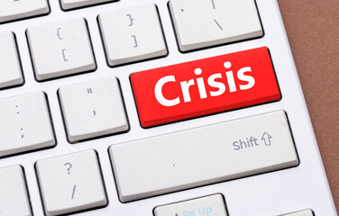 The red button on the keyboard with the word Crisis. Concept in business - difficult times for the economy around the world.