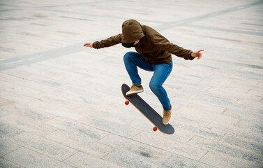 Asian woman skateboarder skateboarding in modern city