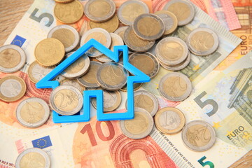 a small blue house on bills and coins