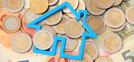 a small blue house on bills and coins