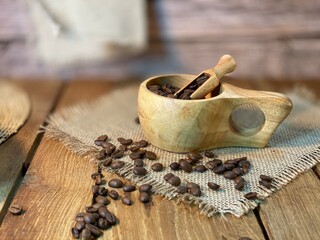 rozsypane Zairka kawy na stole drewnianym dębowym w naczyniach drewnianych i lnianej serwetce - obrazy, fototapety, plakaty