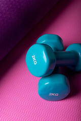 Two blue dumbbells on a yoga mat. Healthy lifestyle concept