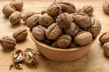 bunch of walnuts in a wooden plate on the table