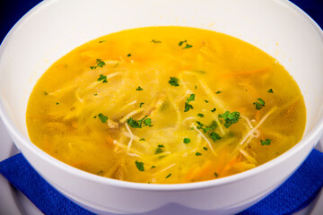 Hot chicken noodle soup with carrots and herbs