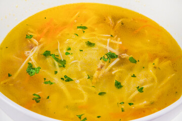 Hot chicken noodle soup with carrots and herbs