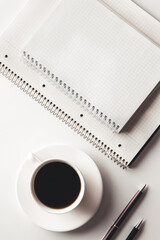 Office desk table with supplies, coffee cup and flower. Top view